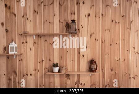Old lamps or Retro lantern and pot with ivy plant on shelves at wooden wall. Front view. Abstract background or wallpaper