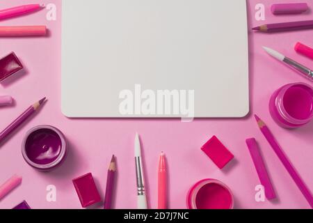 Painter working desk with watercolor, gouache, acrylic, palette, pencils, pastel, brush, sketchbook mockups on pink background. Flat lay. Top view Stock Photo