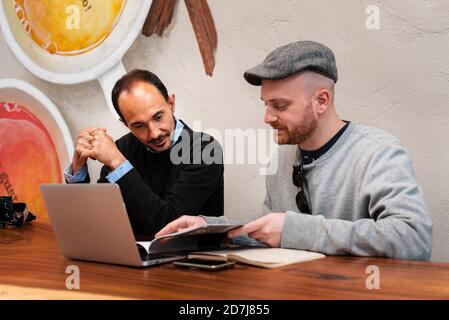 Mid adult and mature man having meeting in coffee shop Stock Photo