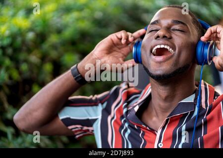 Young man enjoying music on headphones at cafe Stock Photo