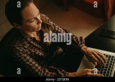 Serious female entrepreneur working on laptop in office Stock Photo