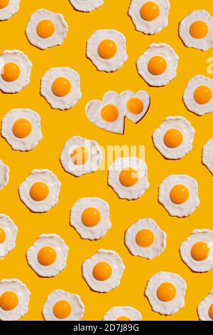 Pattern of fried eggs against yellow background Stock Photo