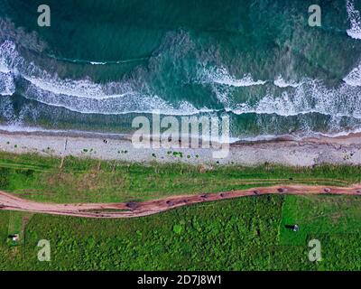 Aerial view of dirt road stretching along coastline of Krabbe Peninsula Stock Photo
