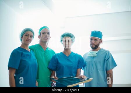 Confident team of surgeons standing with medical x-ray image in hospital Stock Photo