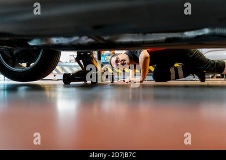 Male mechanic examining car tire in auto repair shop Stock Photo