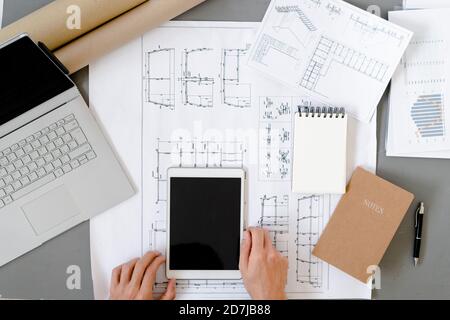 Man using digital tablet while working by desk at office Stock Photo