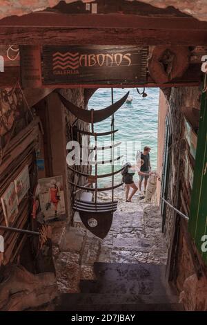 Art gallery in a cobbled passage with access to the to seafront with a view of two tourists, Rovinj, Croatia Stock Photo