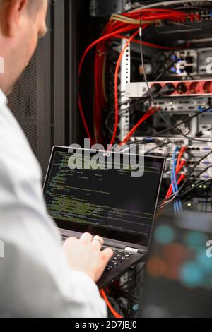 Close-up of male IT professional using laptop in data center Stock Photo