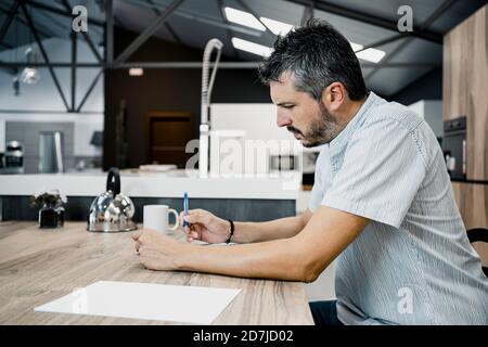 Mature male freelancer working while sitting at desk in office Stock Photo