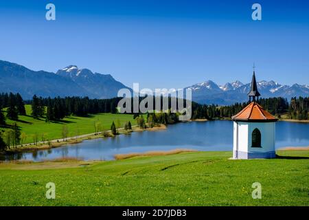 Germany, Bavaria, Hegratsried, Chapel in front of Hegratsrieder See lake in summer Stock Photo