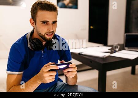 Handsome man enjoying while playing video game at home Stock Photo
