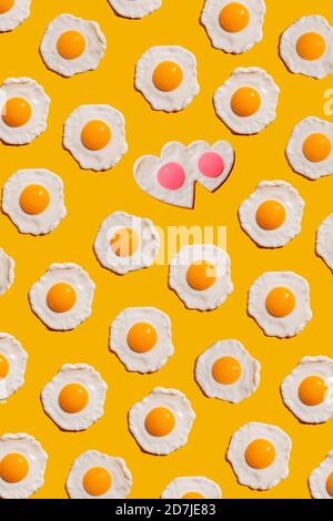 Pattern of fried eggs against yellow background Stock Photo