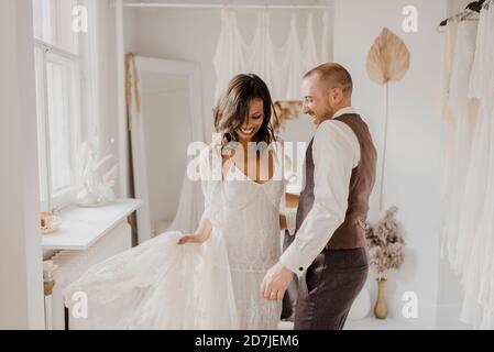 Smiling couple dancing at wedding dress shop Stock Photo