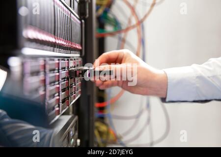 Close-up of male engineer examining computer equipment in data center Stock Photo