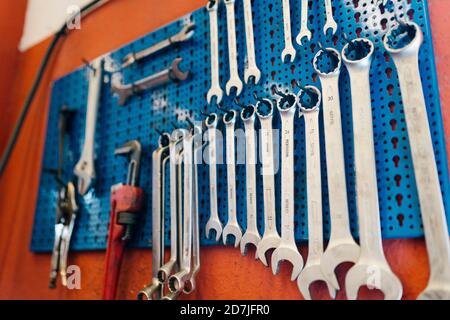 Close-up of work tools hanging on pegboard in workshop Stock Photo