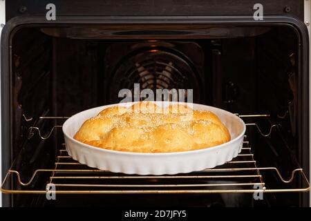 Homemade apple pie sprinkled with sesame seeds cooked in the domestic oven. Shallow focus. Stock Photo