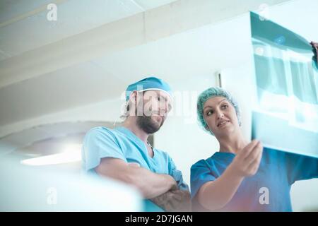 Male and female doctors discussing over medical x-ray image in hospital Stock Photo