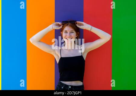 Italy, Province of Cuneo, Barolo, Portrait of young beautiful woman posing in front of colorful wall of Chapel of Barolo Stock Photo