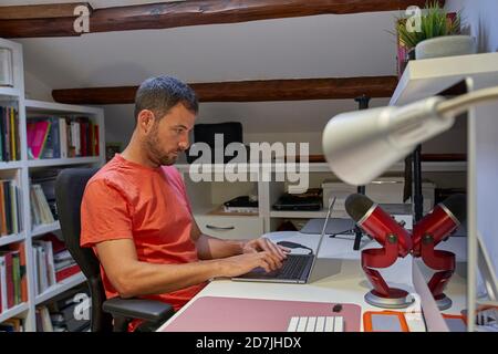Mid adult man working on laptop from home Stock Photo