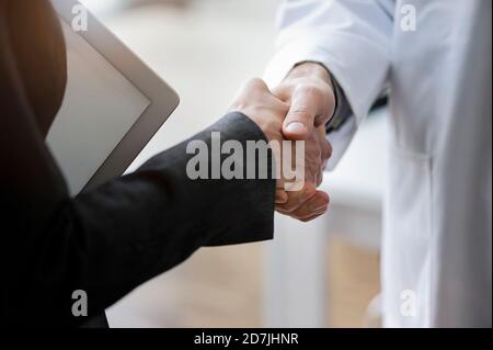 Close-up of male and female partners giving handshake in office Stock Photo