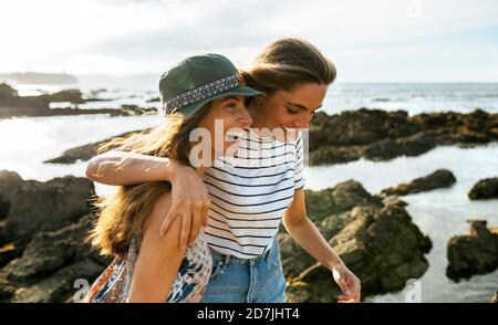 Cheerful young sisters enjoying at beach during weekend Stock Photo