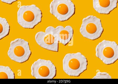 Pattern of fried eggs against yellow background Stock Photo