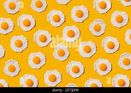 Pattern of fried eggs against yellow background Stock Photo