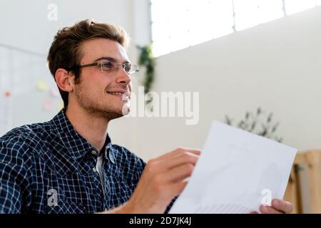 Young man smiling while working at office Stock Photo