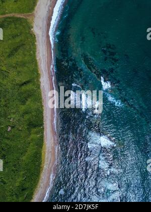 Aerial view of dirt road stretching along coastline of Krabbe Peninsula Stock Photo