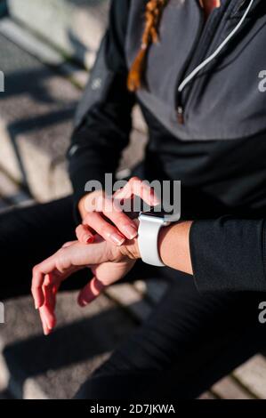 Close-up of female athlete using smart watch while sitting on steps Stock Photo