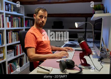 Mid adult man working on computer from home Stock Photo