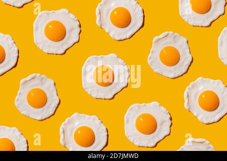 Pattern of fried eggs against yellow background Stock Photo