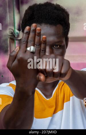 Young man showing hands while standing against container Stock Photo