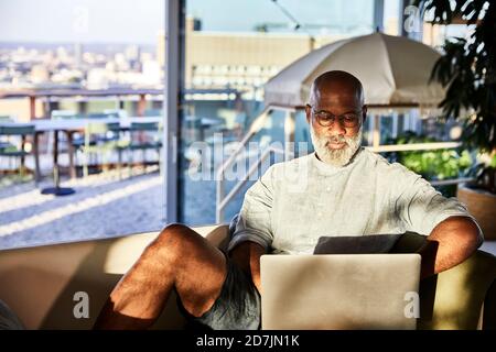 Mature man working from home while using laptop Stock Photo