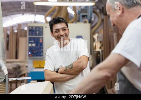 Smiling coworkers working together at workshop Stock Photo