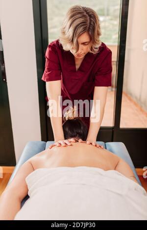 Physiotherapist massaging woman s upper back Stock Photo - Alamy