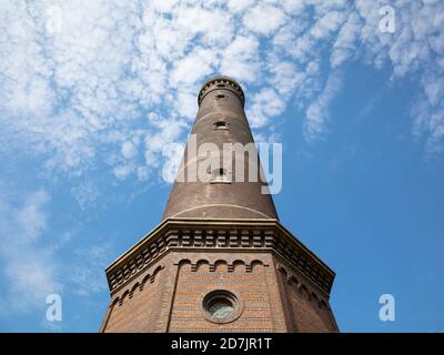 Tall lighthouse against blue sky on sunny day Stock Photo