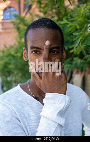 Man covering with face with hand while standing at public park Stock Photo
