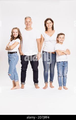 Smiling family standing against white background Stock Photo