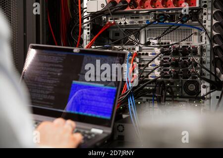 Close-up of male IT professional using laptop in server room Stock Photo