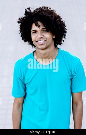 Smiling young man standing against wall Stock Photo