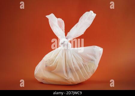 plastic bag with fruits agains orange background, zero waste and environment  pollution concept Stock Photo