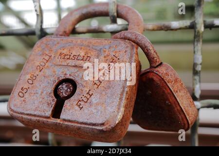Old rusty padlocks as a symbol for love, attached to a wire-mesh fence. Translation of the text: "05.08.2011" - "Kristin" - "For ever!" Stock Photo