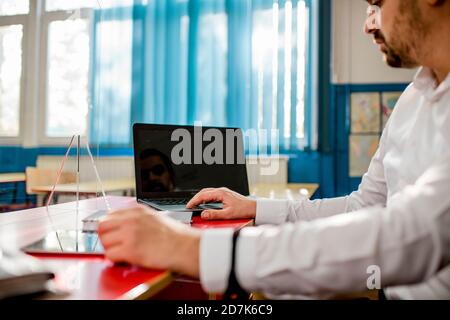 Professor in classroom using laptop and digital tablet Stock Photo