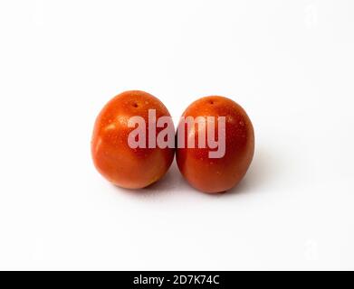 Two tomatos on white background with water drops Stock Photo