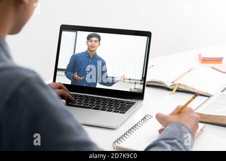 Young collage student using computer and mobile device studying online. Education and online learning. Stock Photo
