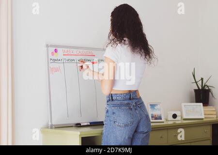 woman writing on a white board planning the tasks Stock Photo