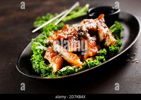 Japanese eel grilled or Unagi ibaraki set on plate, eel with sesame and unagi sauce Stock Photo