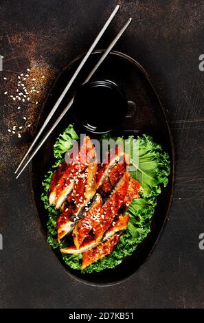 Japanese eel grilled or Unagi ibaraki set on plate, eel with sesame and unagi sauce Stock Photo