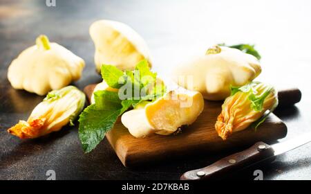 raw pattisons on wooden board, vegetable on board Stock Photo